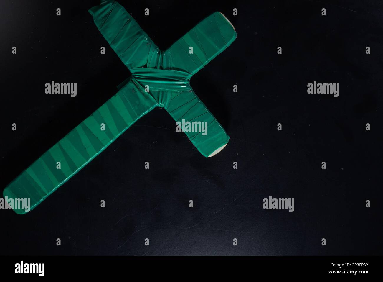 christian crucifix and rosary beads on abstract grey background