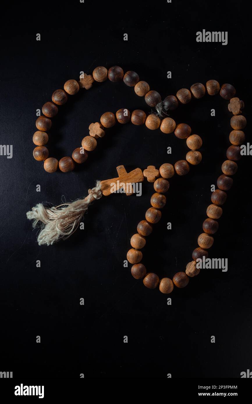 christian crucifix and rosary beads on abstract grey background