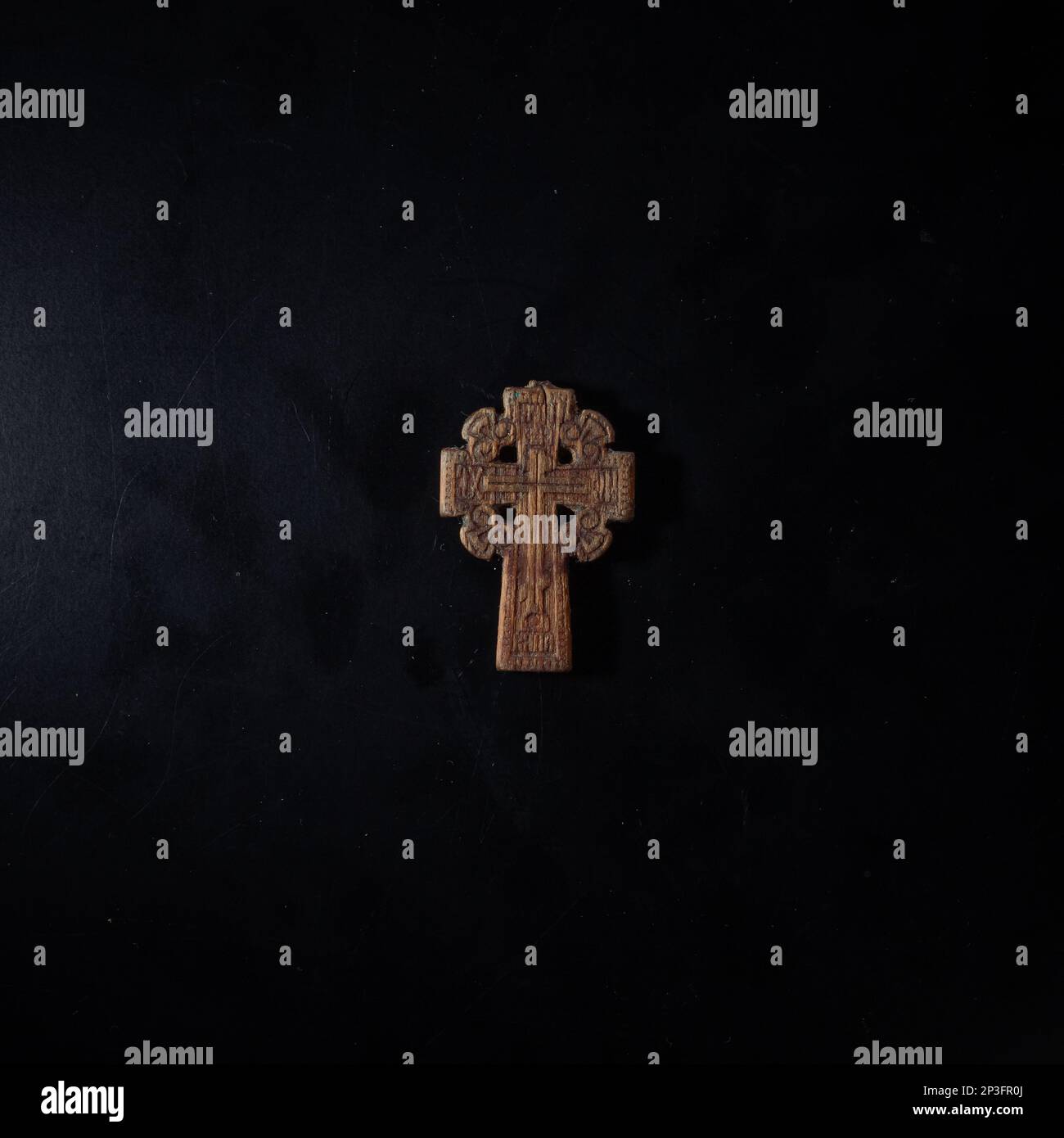 christian crucifix and rosary beads on abstract grey background