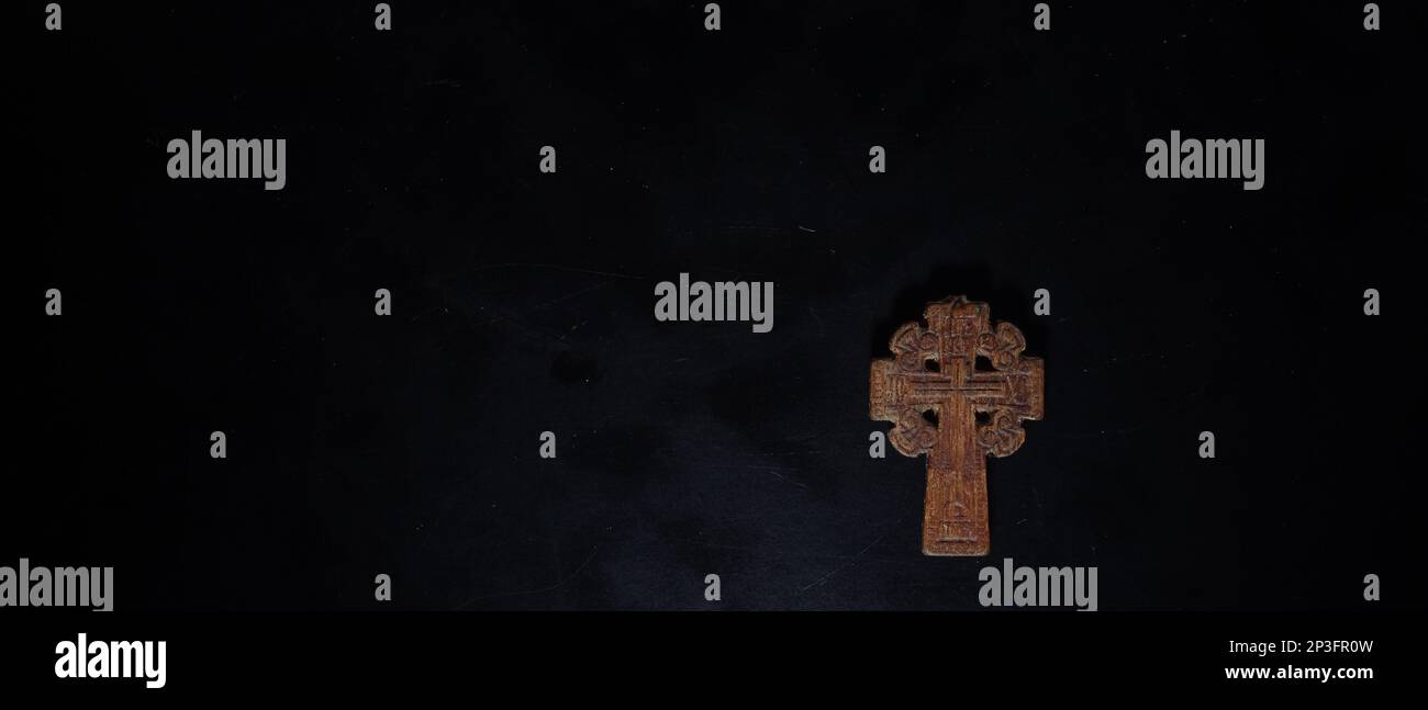 christian crucifix and rosary beads on abstract grey background