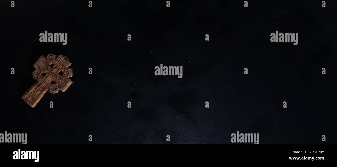 christian crucifix and rosary beads on abstract grey background