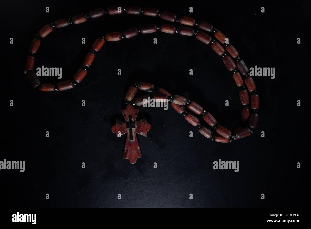 christian crucifix and rosary beads on abstract grey background