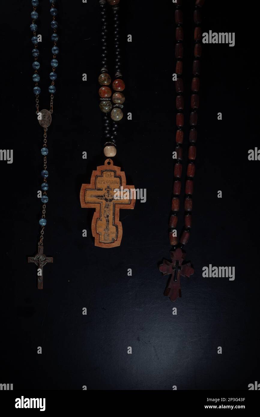 christian crucifix and rosary beads on abstract grey background