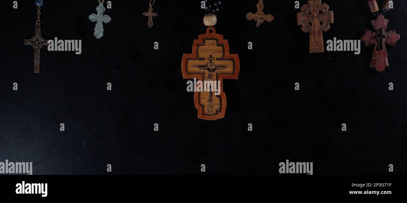 christian crucifix and rosary beads on abstract grey background
