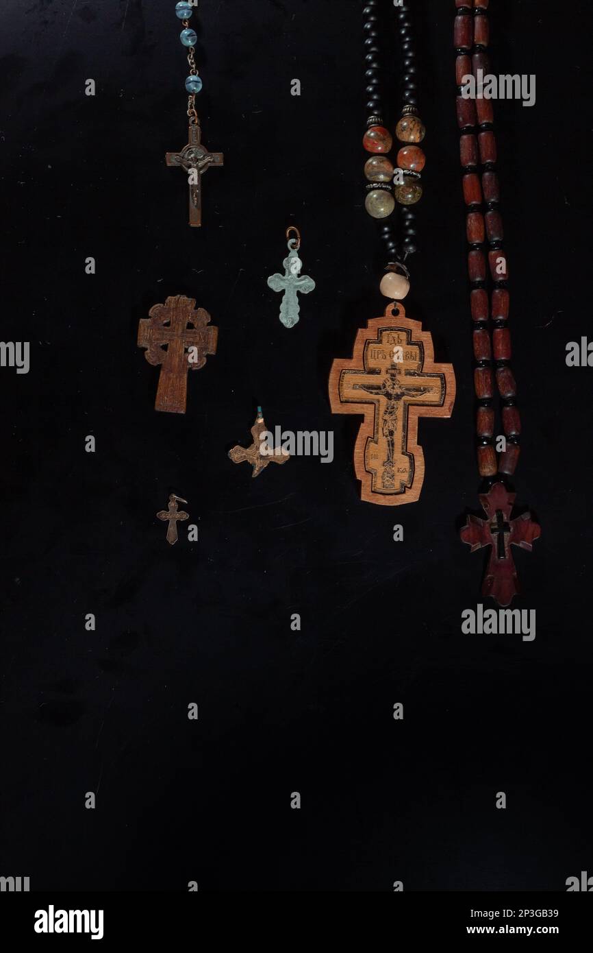 christian crucifix and rosary beads on abstract grey background