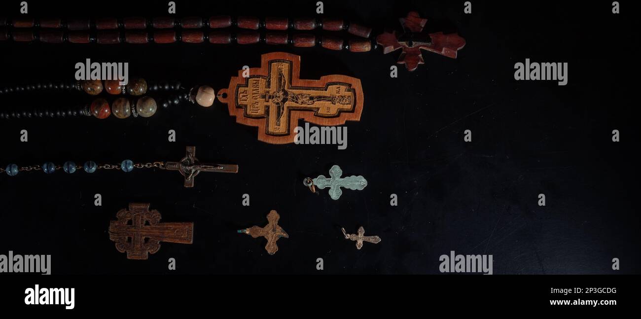 christian crucifix and rosary beads on abstract grey background