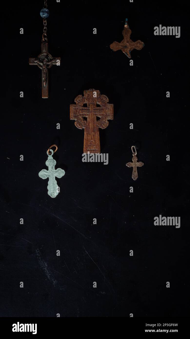 christian crucifix and rosary beads on abstract grey background