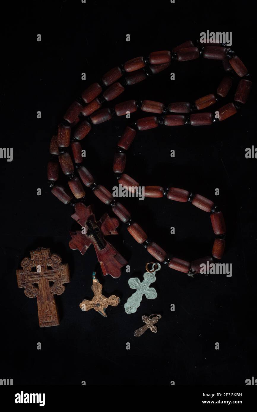 christian crucifix and rosary beads on abstract grey background