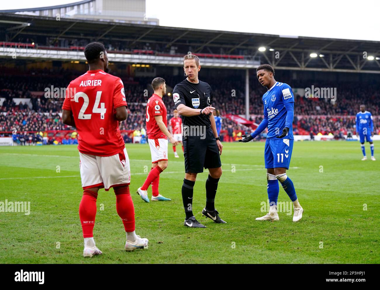 Referee John Brooks speaks to Everton's Demarai Gray (right) and Nottingham Forest's Serge Aurier during the Premier League match at the City Ground, Nottingham. Picture date: Sunday March 5, 2023. Stock Photo