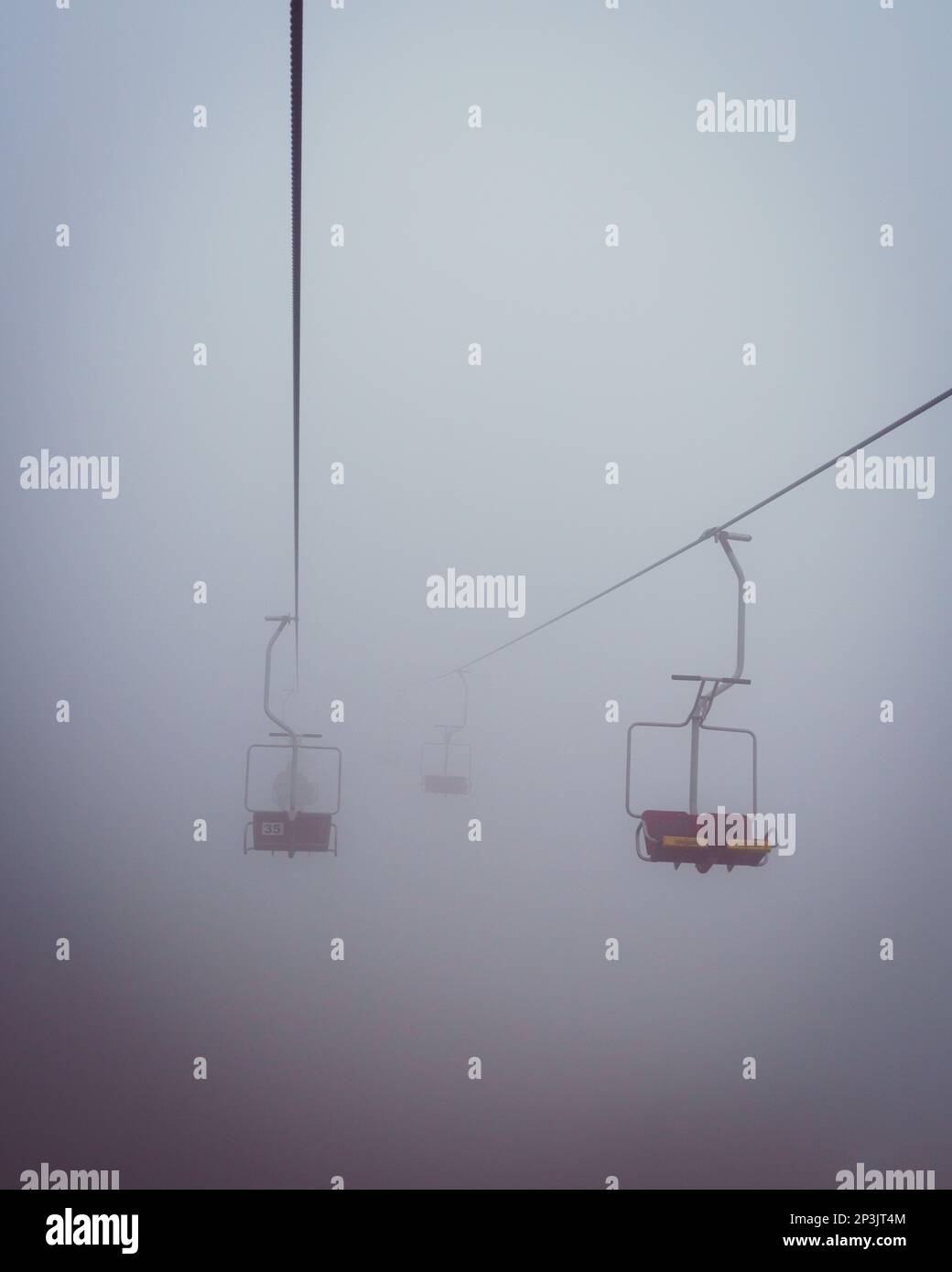 2022 12 30, Velika Planina, Slovenia: A chair lift in deep fog, riding into unknown future Stock Photo