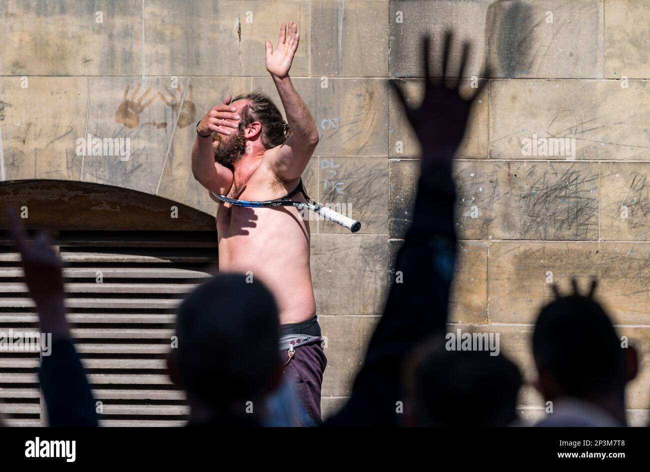 Street entertainer contortionist performing during festival with a tennis racquet, Royal Mile, Edinburgh, Scotland, UK Stock Photo