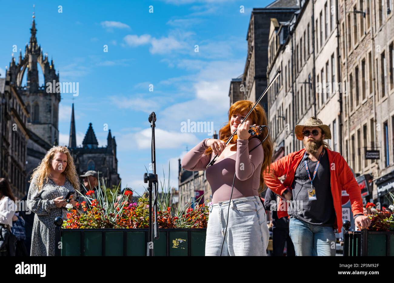 Street entertainer Meg Lagrande busking playing a fiddle or violin performing during festival, Royal Mile, Edinburgh, Scotland, UK Stock Photo