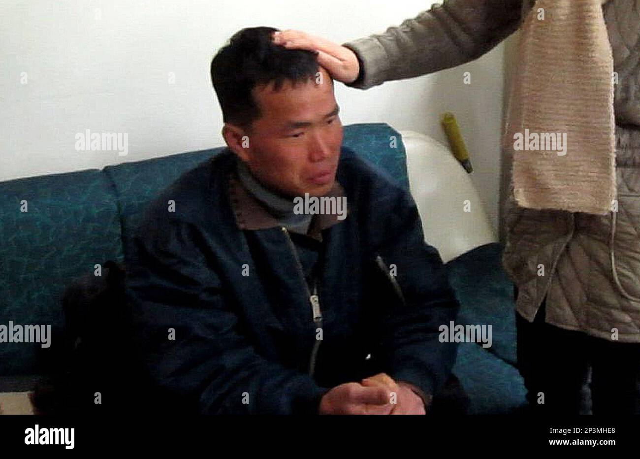 FILE - In this Jan. 24, 2014 file image taken from a video footage released  by Guro Police, Kim Seong-baek, left, meets with his mother, not identified  her name, after he was