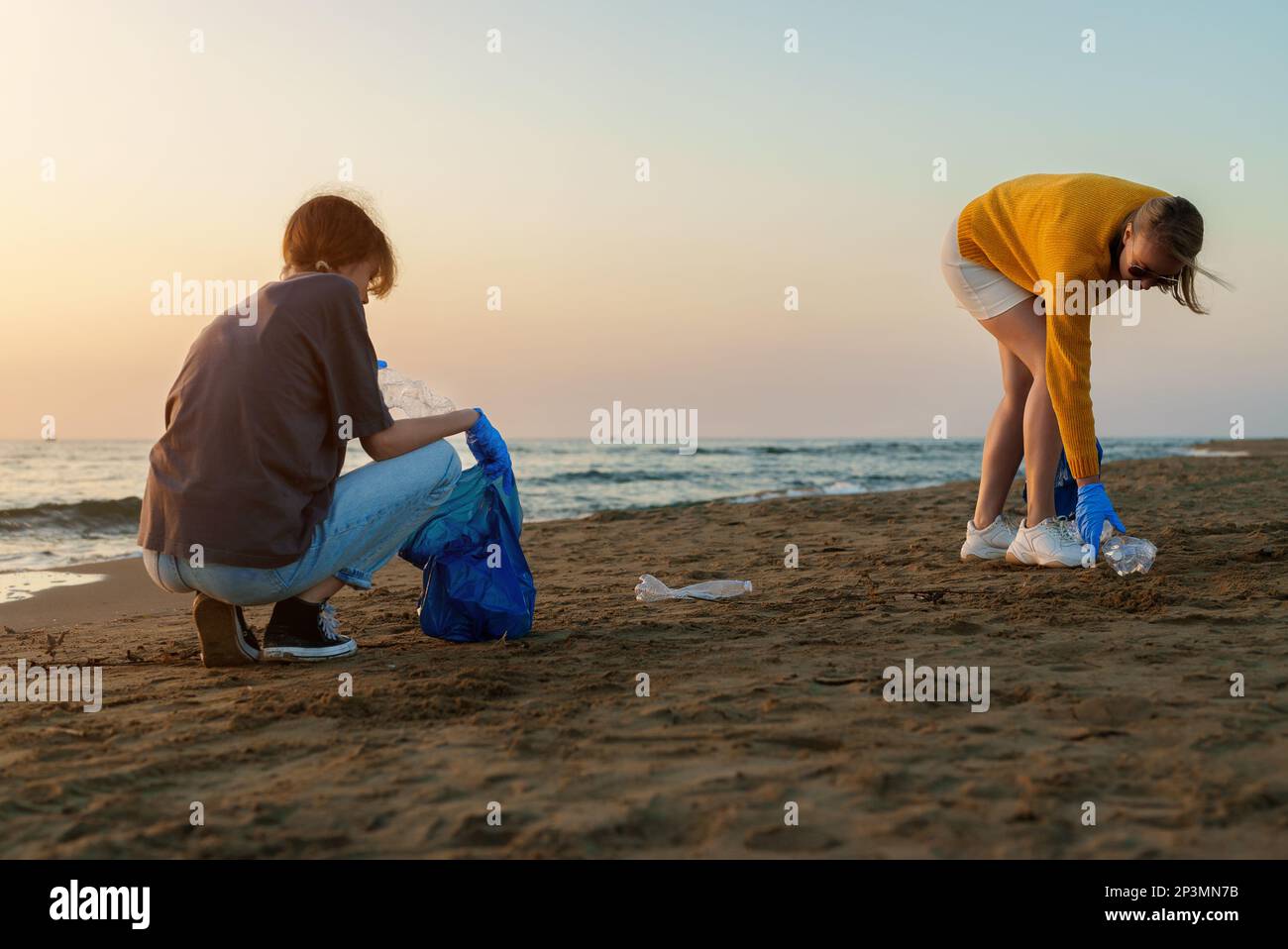Mother with daughter saving the planet from garbage. Stock Photo