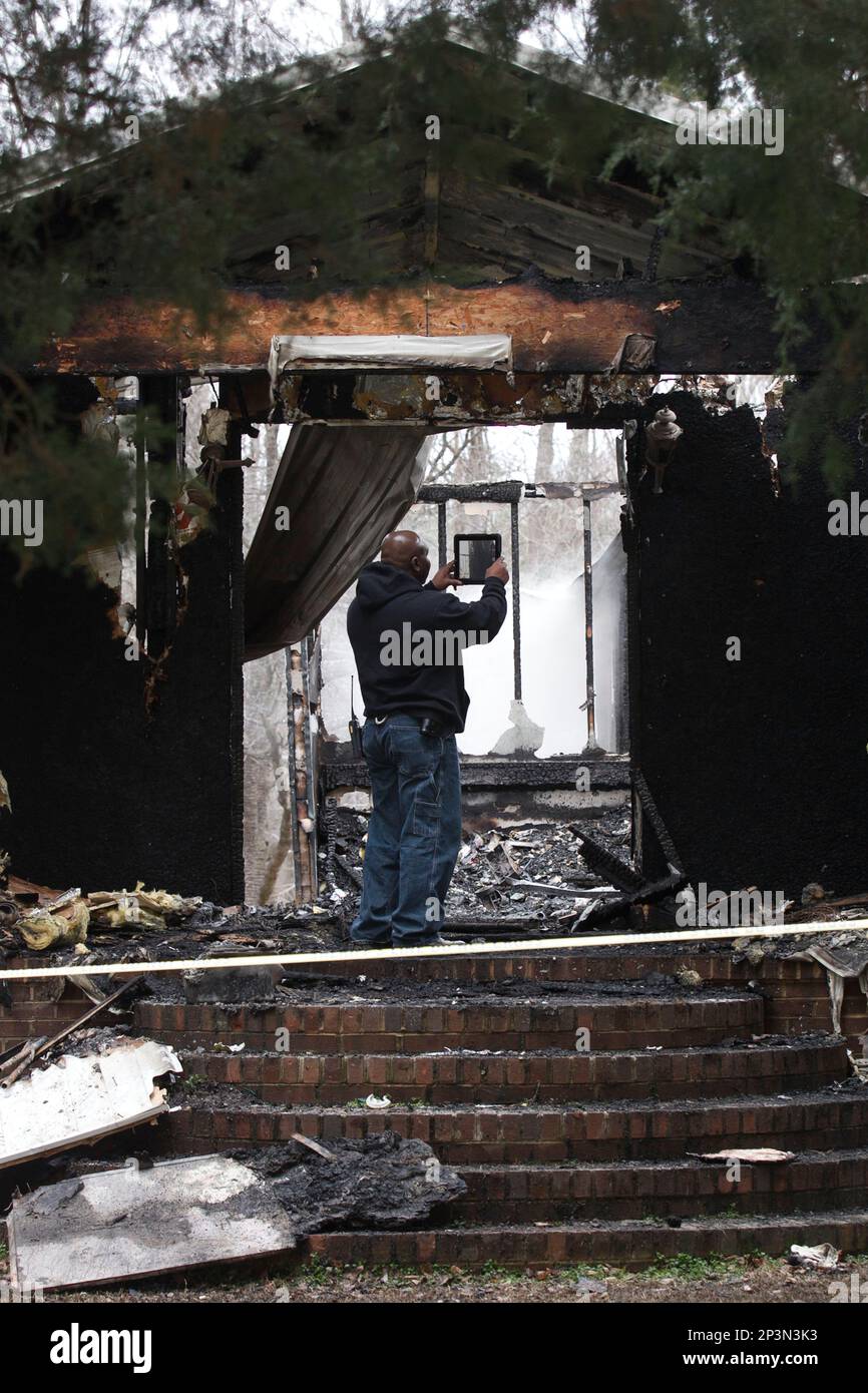 A Granville County authority surveys the damage to the burned the home