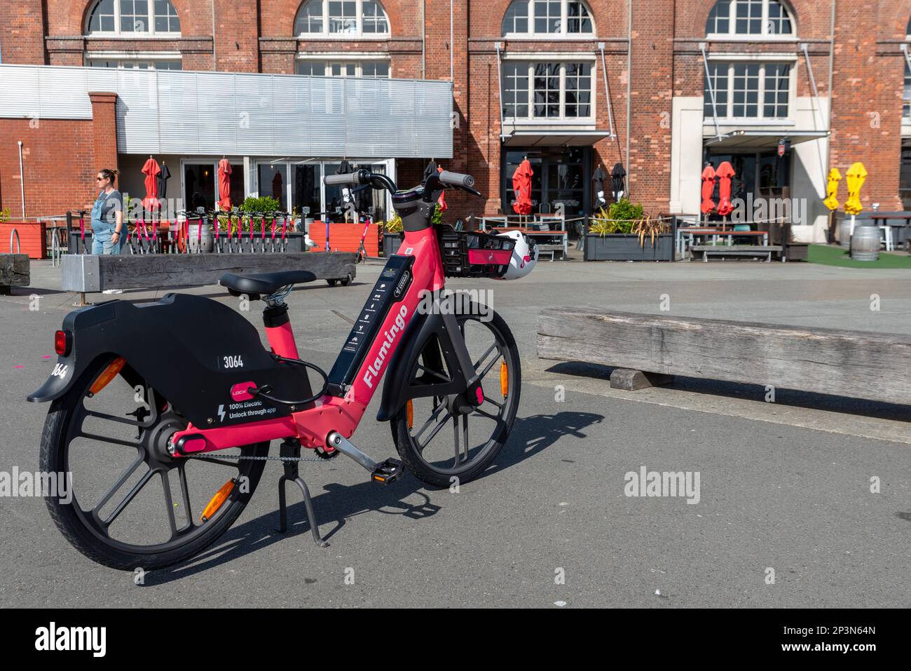 Flamingo electric bicycle for hire, Wellington, New Zealand. Dockless e bike hire scheme, parked by harbourside Mac's Brewbar restaurant. Trial scheme Stock Photo