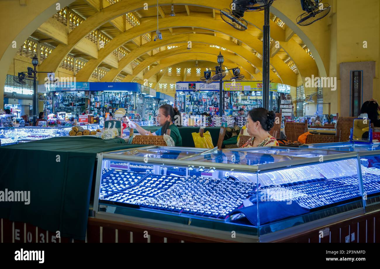 Two women sit at a jewellry stall in the art deco Central Market in Phnom Penh, Cambodia. Stock Photo