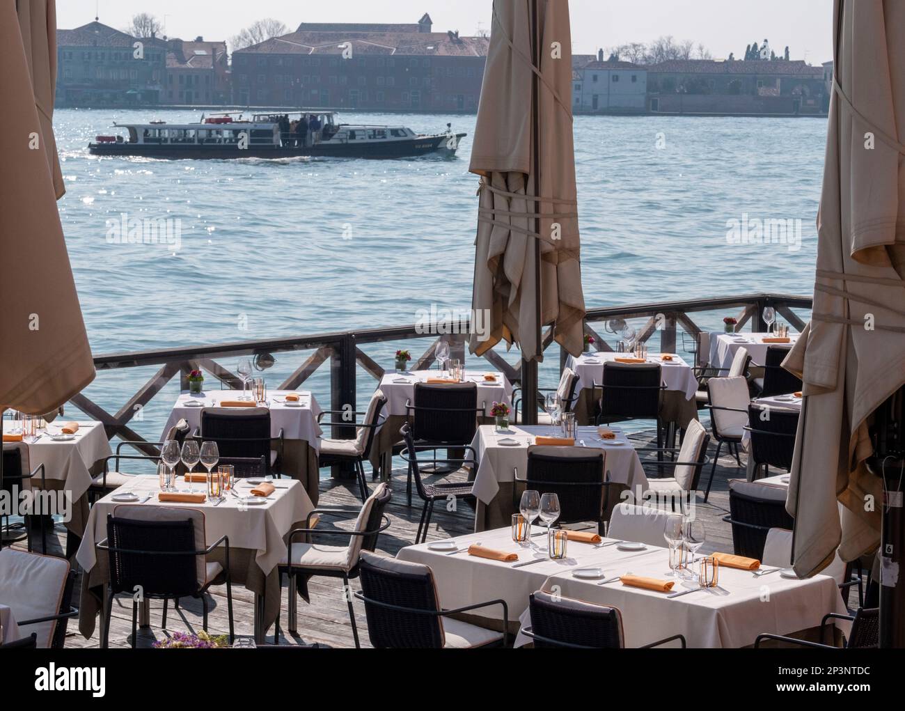 Outdoor restaurant on the embankment of the Canale Della Giudecca, overlooking the Isola di San Giorgio Maggiore, Venice, Italy. Stock Photo
