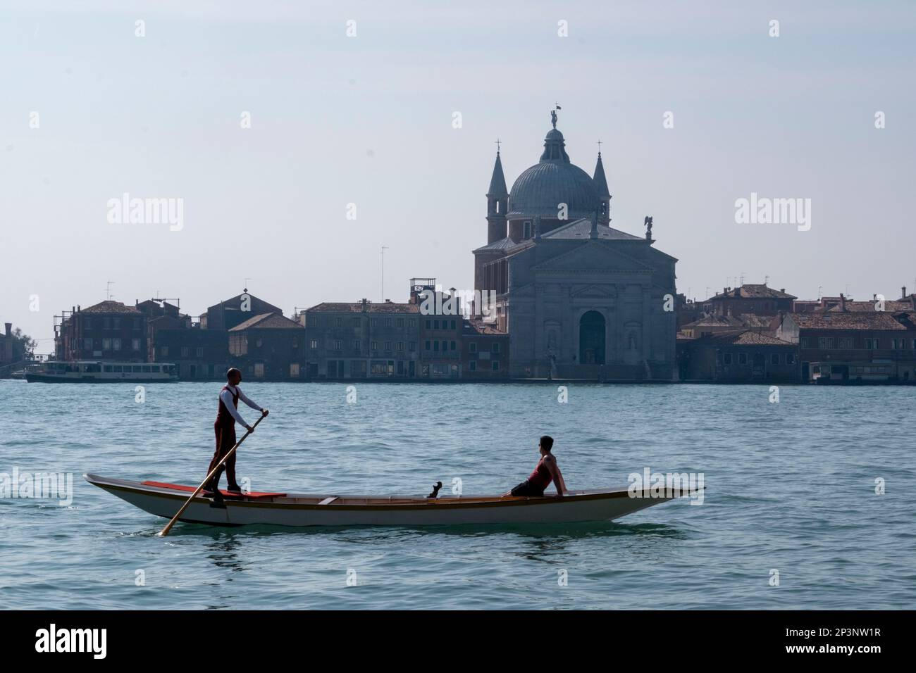 Two men on a Gondola in the Canale della Guidecca, Venice, Italy Stock Photo