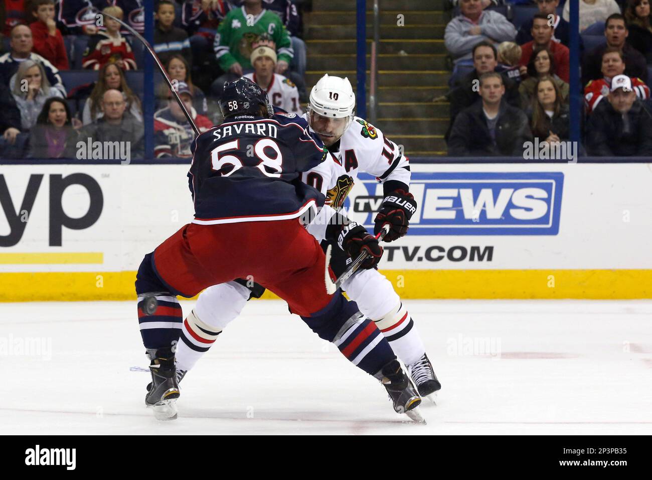 Dec 20, 2014; Columbus Blue Jackets defenseman David Savard (58) checks Chicago Blackhawks left wing Patrick Sharp (10) off the puck in the overtime period during the NHL game between the Chicago