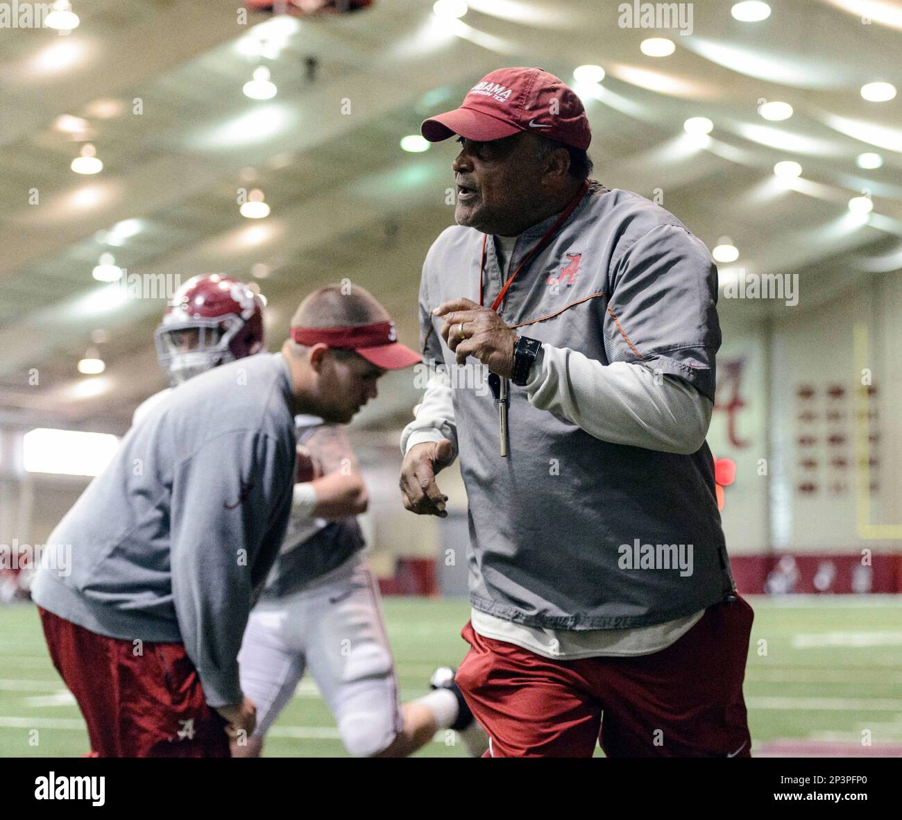 Alabama running backs coach Burton Burns works his running backs