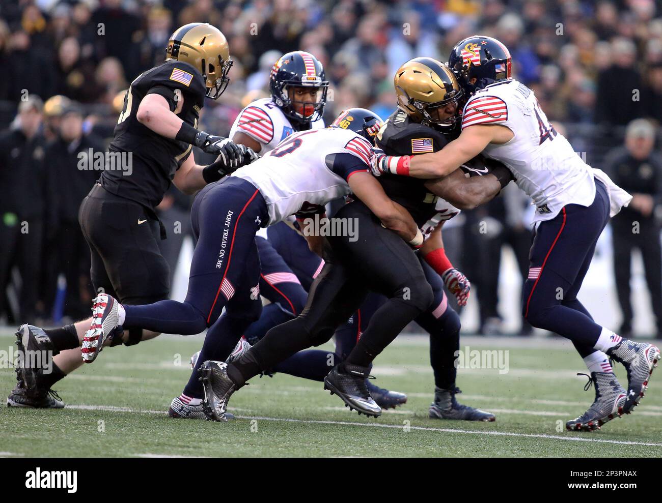 December 13, 2014: Army running back Larry Dixon (26) runs through Navy  linebacker Chris Johnson (46) and Navy running back Darryl Bonner (42)  during a match between Army and Navy at M&T
