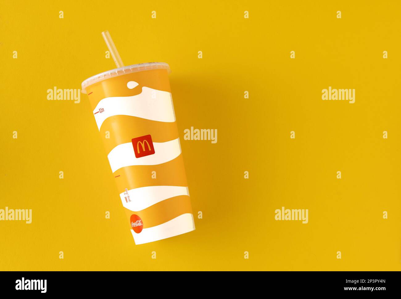 Yellow glass of McDonald's. Paper cup with lid. Takeaway drink ...