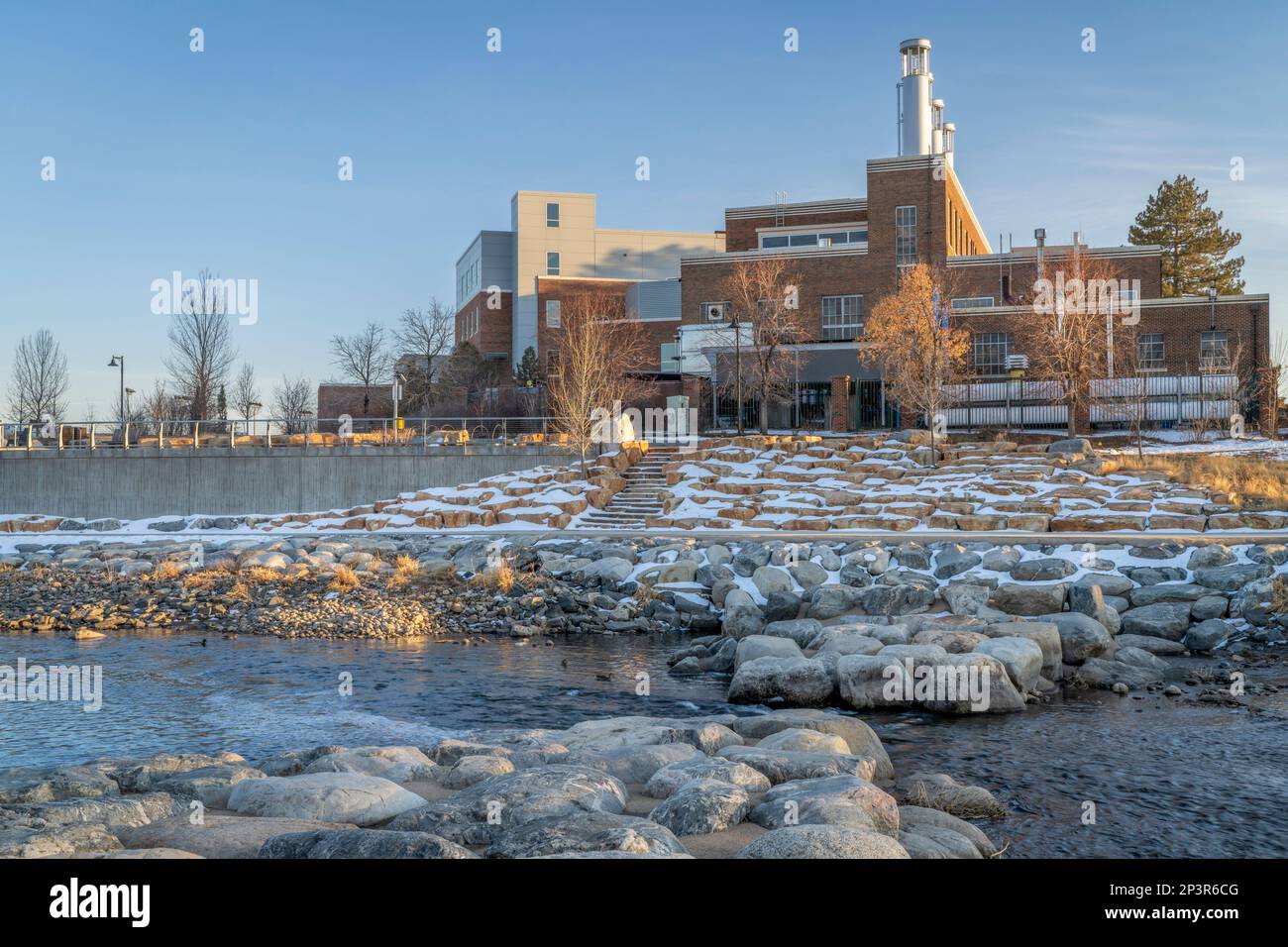 Poudre River at a whitewater park in downtown of Fort Collins Colorado with Powerhouse Energy Campus of Colorado State University in background, winte Stock Photo