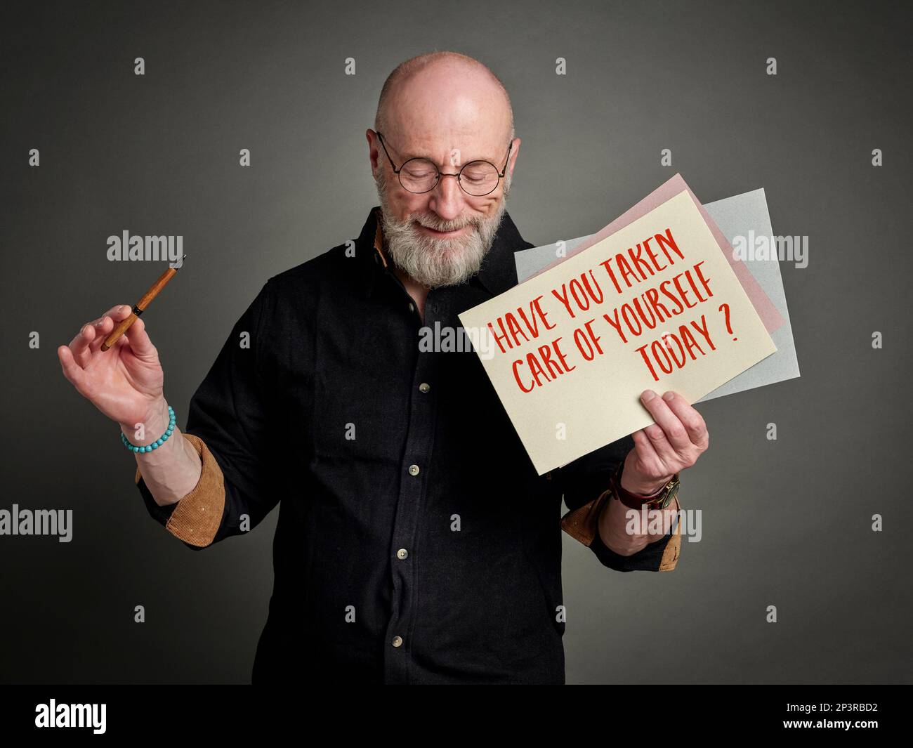 Have you taken care of yourself today? Self care concept. A note held by a happy, relaxed senior man. Stock Photo