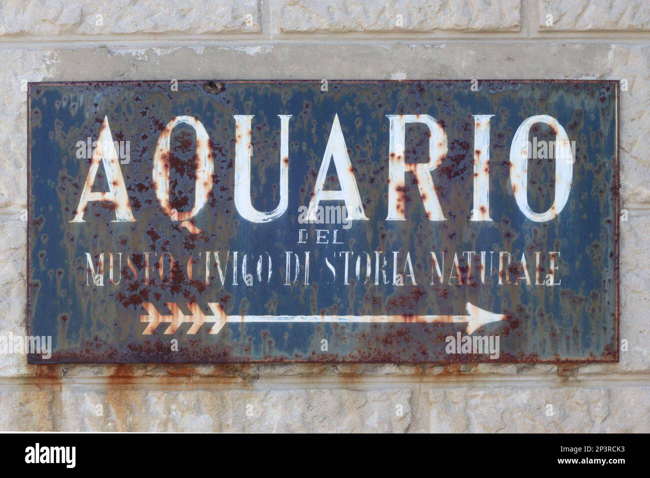 An original weathered wall mounted italian sign directing pedestrians to the Aquarium in Trieste, Italy September 2022. Stock Photo
