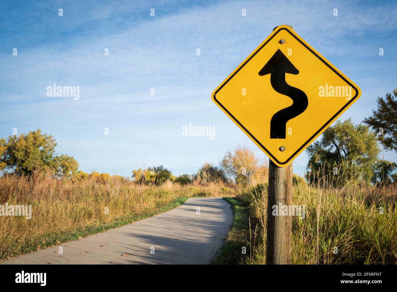 sharp curve ahead or winding road - warning sign on a bike trail in northern Colorado Stock Photo