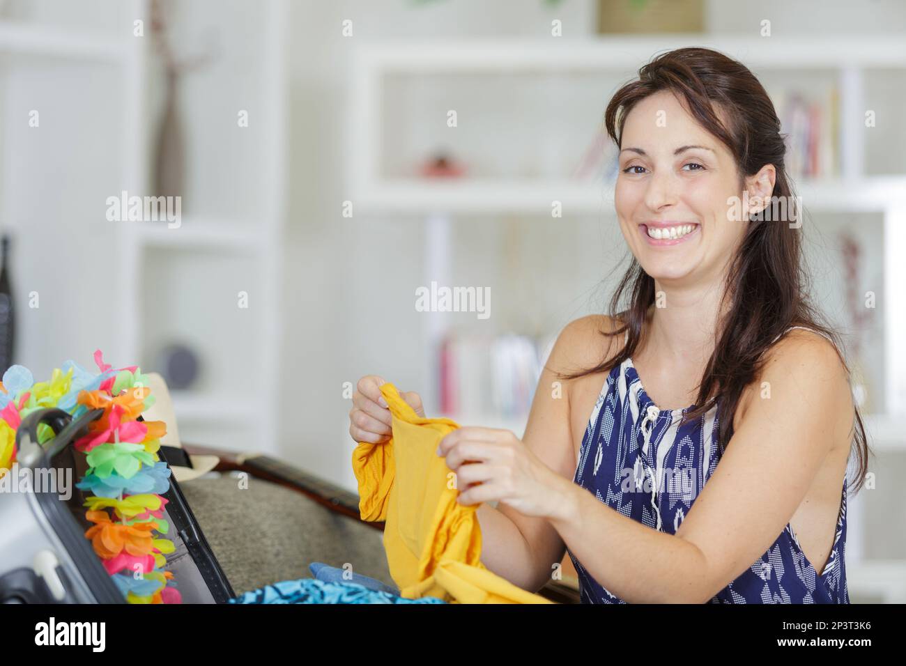 woman folding her clothes to be put in the suitcase Stock Photo Alamy