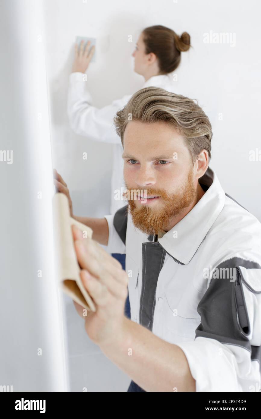 male worker in sanding a wall Stock Photo