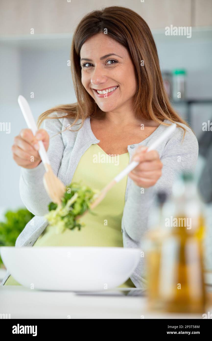smiling woman mix sald in glass bowl Stock Photo