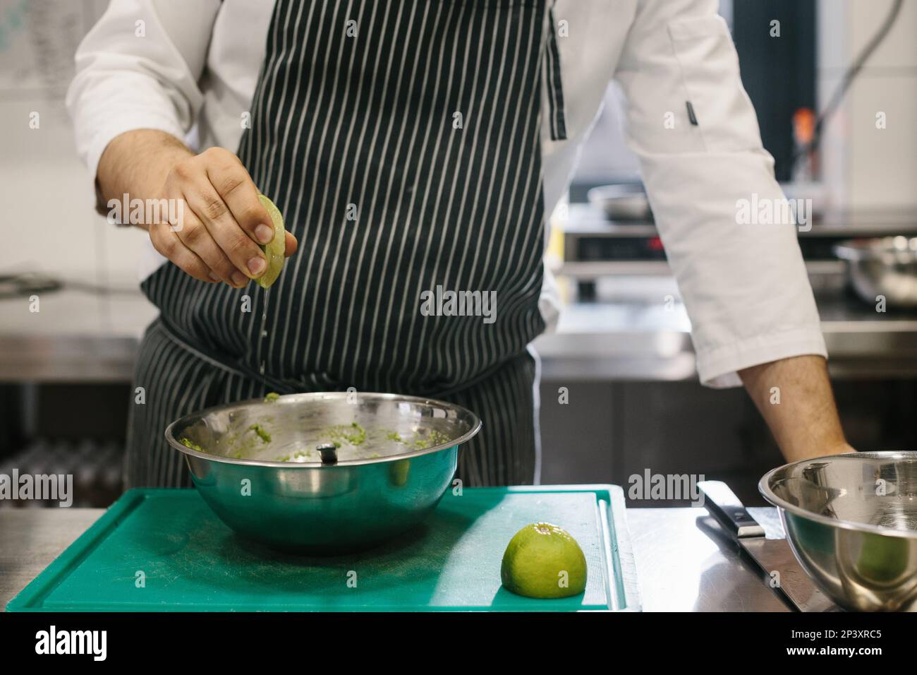 The chef is preparing food. Close-up of a male chef preparing avocado toast in a spacious modern kitchen. Stock Photo
