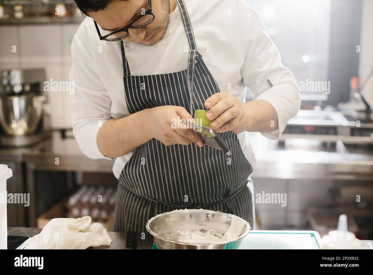 The middle section is a portrait of a chef grating lime zest. The concept of cooking in a restaurant. Stock Photo