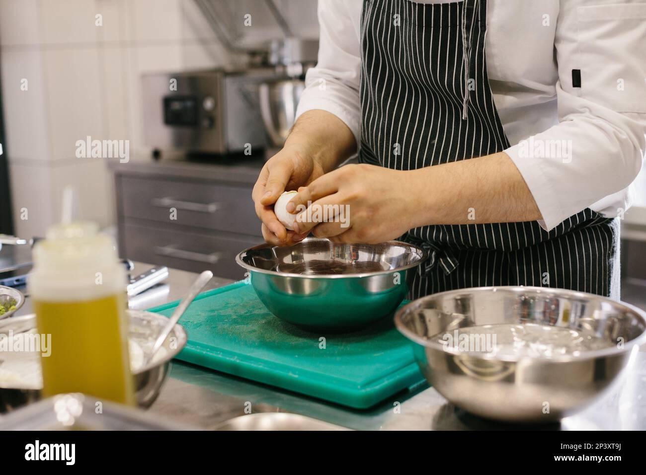 Close up. A male cook is cleaning boiled eggs in the kitchen of a restaurant. Stock Photo
