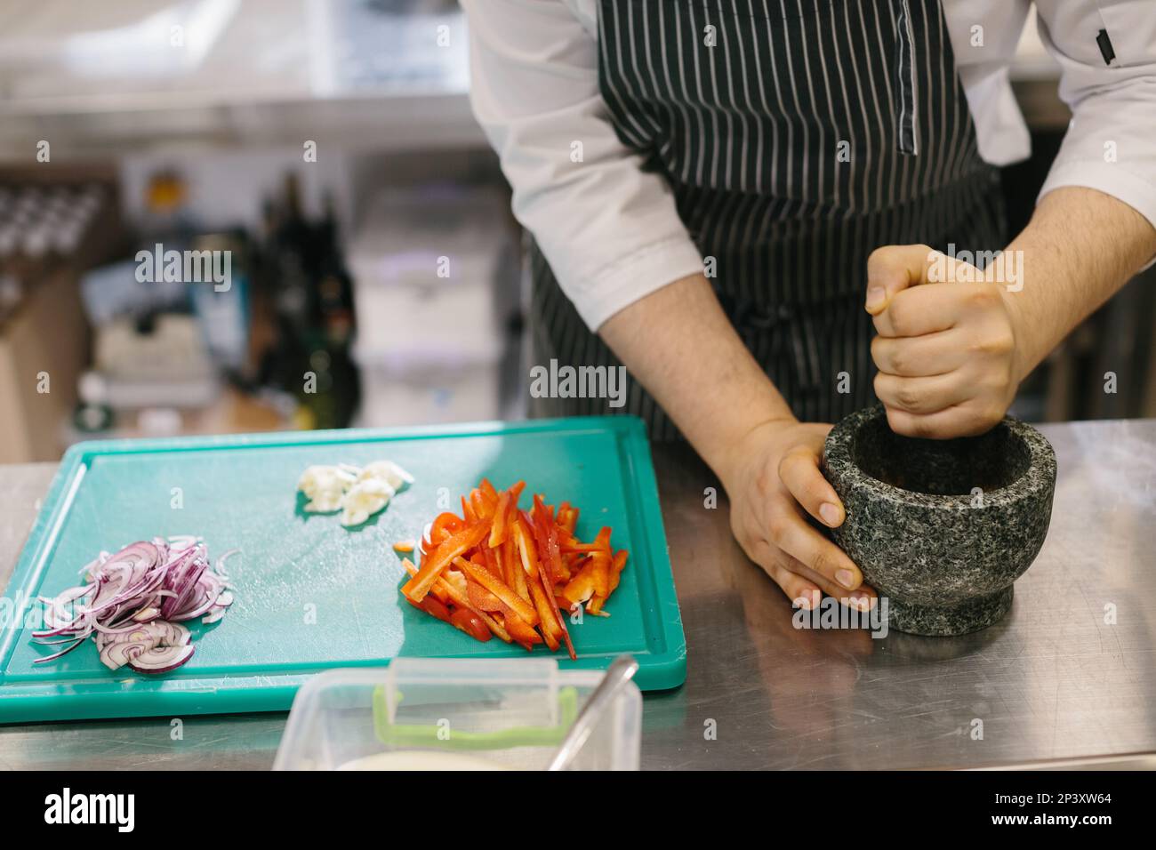 Close-up of a male chef preparing garlic sauce for a restaurant. Stock Photo