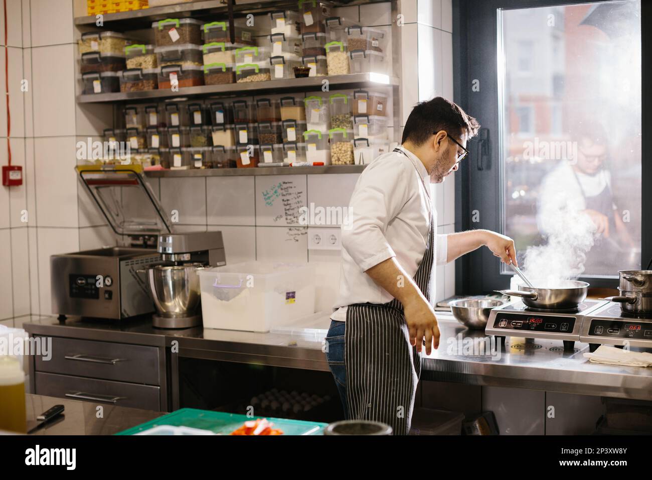 Сooking food, profession and people concept - male chef cook with frying pan at restaurant kitchen. Stock Photo