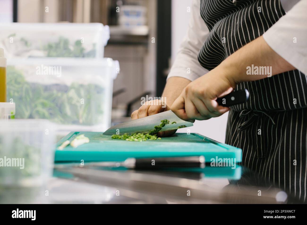 Close up, male chef cuts vegetables in restaurant. Stock Photo