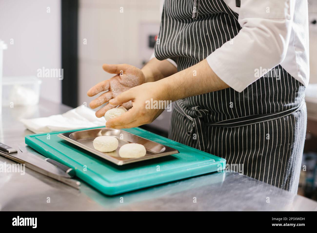 The chef prepares cheese pancakes in the kitchen of the cafe. Stock Photo