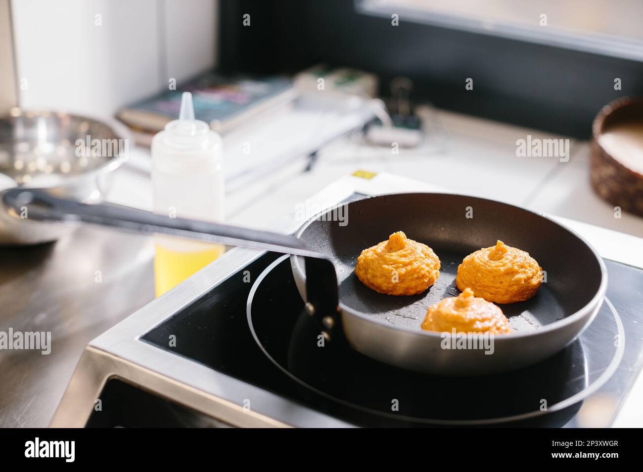 Carrot pancakes are fried in a pan, close-up. Stock Photo