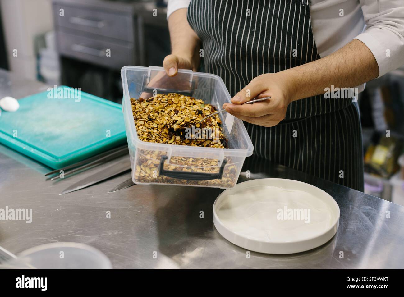 The process of making muesli in a restaurant, a male chef is working in the kitchen. Stock Photo