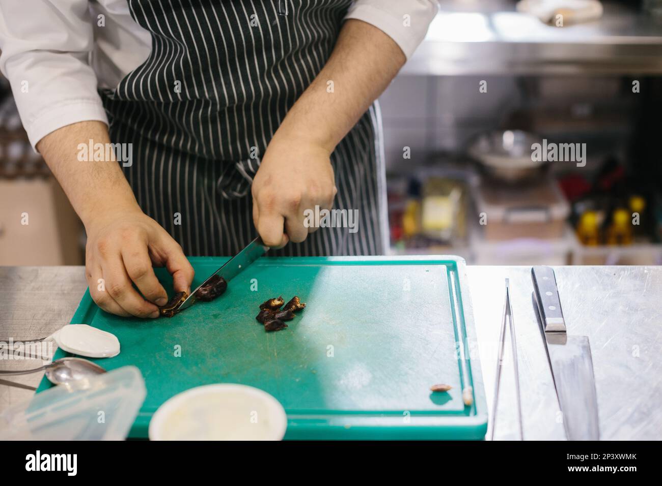 The process of making muesli in a restaurant, the male chef cuts dates