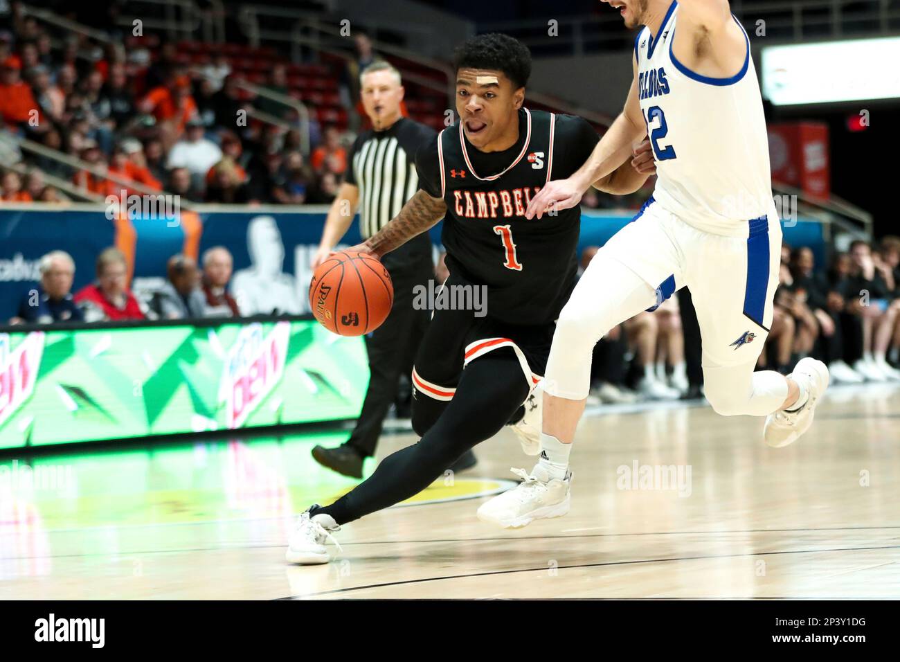 CHARLOTTE, NC - MARCH 05: Fletcher Abee (12) of the North  Carolina-Asheville Bulldogs defends Ricky Clemons (1) of the Campbell  Fighting Camels as he drives to the basket during the Big South