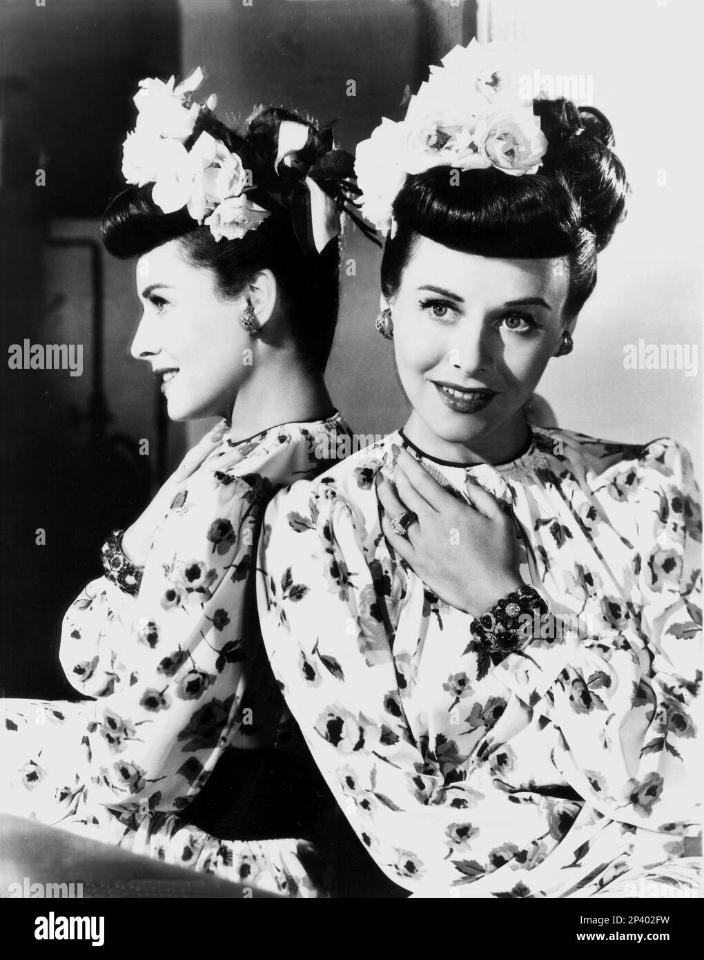 The american actress PAULETTE GODDARD ( 1910 - 1990 ) - CINEMA - chignon - specchio - mirror - riflesso - reflex - fiori - fiore - flowers - rose - rosa - rings - anello - anelli - bracelet - braccialetto - orecchini - earrings - orecchino - bijoux - gioiello - gioielli - jewels - jewellery - profilo - profile  - smile - sorriso - hands - mano - mani   ---- Archivio GBB Stock Photo