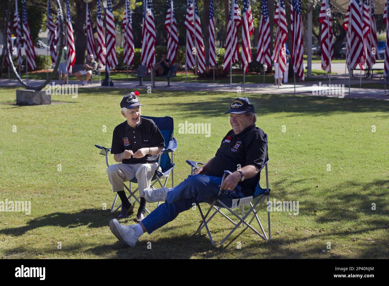 Frank Steinke, left, and Max Zillig talk before the start of the Bonita Springs' Veterans Day memorial service at Riverside Park in Bonita Springs, Fla. on Tuesday, Nov. 11, 2014. The friends met as shipmates on the USS Ticonderoga in 1955. "We traveled around the world together," said Steinke. "The ship almost broke in half." (AP Photo/Naples Daily News, Carolina Hidalgo) Stock Photo