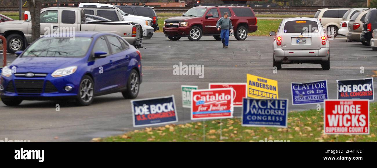 A man walks to his car as other motorists move around the parking lot