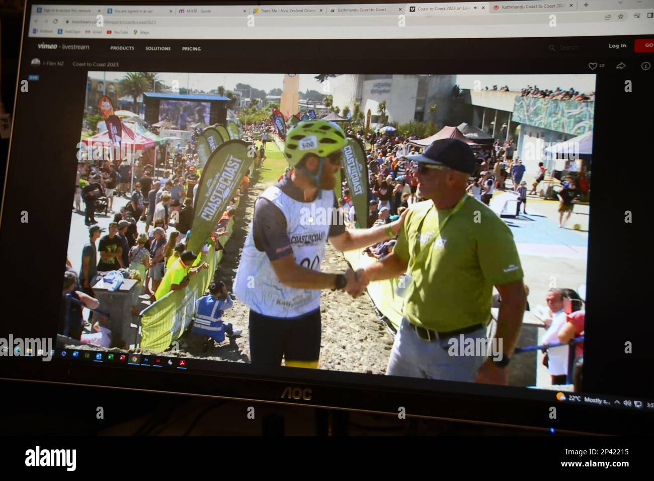 CHRISTCHURCH, NEW ZEALAND, February 11, 2023: Livestream video of the annual Coast to Coast Triathlon displayed on a desktop computer monitor shows co Stock Photo
