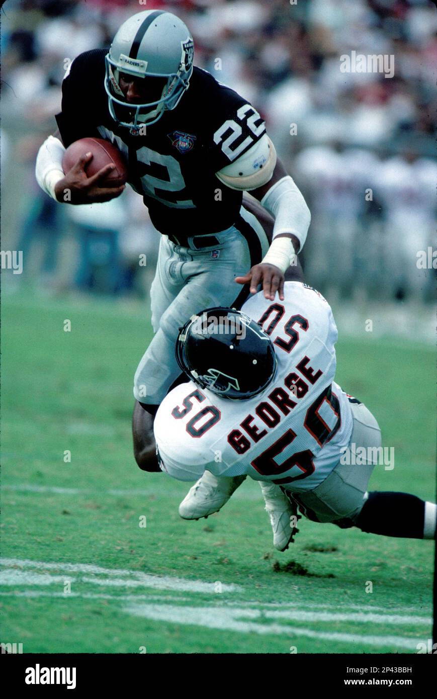 Running back Harvey Williams #22 of the Oakland Raiders is tackled by ...